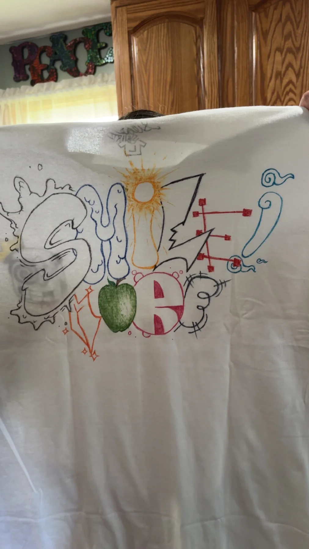White shirt covered in colorful hand-drawn graffiti lettering